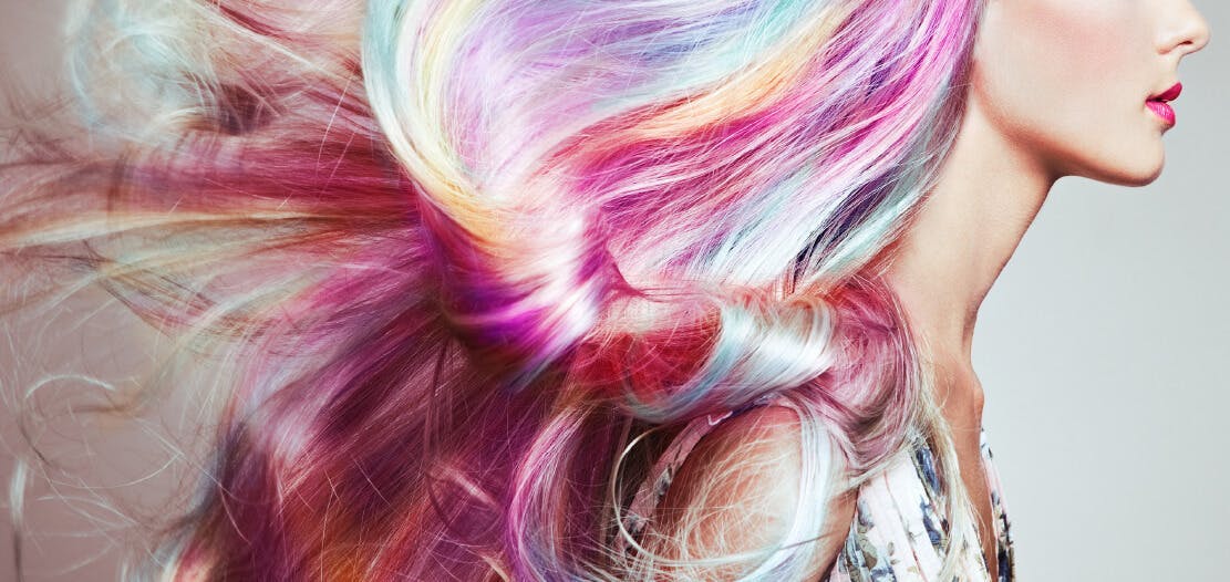 Profile of woman with pastel rainbow hair and cheekbone with highlight