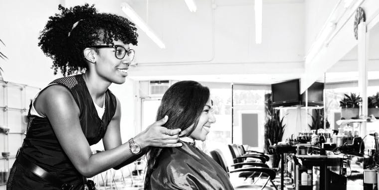 Empire Beauty School student giving a haircut in a salon