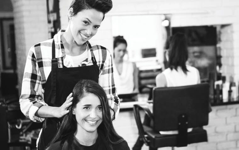 Empire Beauty School student providing hair consultation in a salon